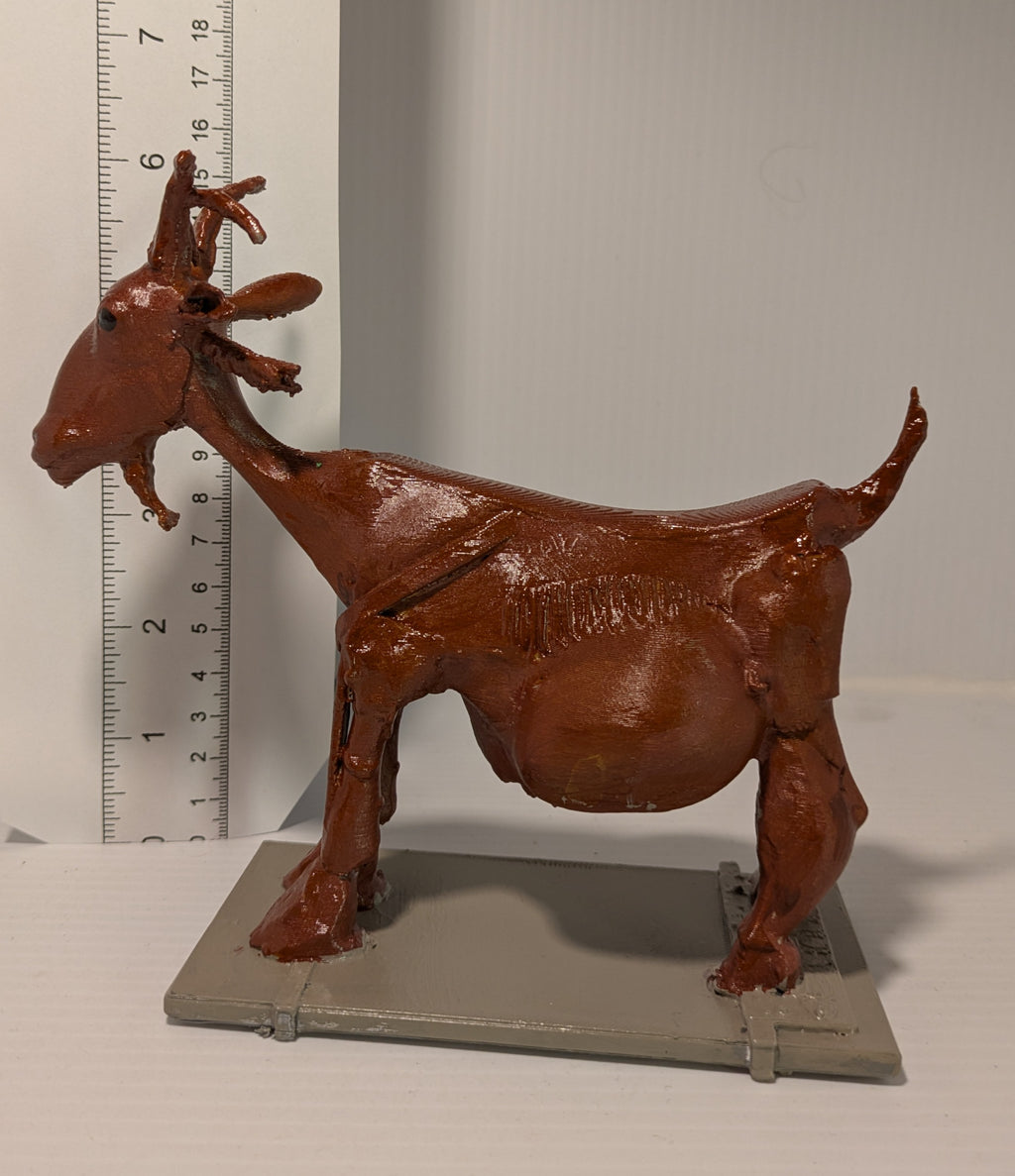 Brown 3D-printed goat model on a gray surface with a ruler for scale.